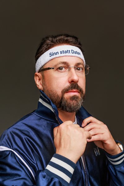 Niko Martzy in blauer Trainingsjacke mit Stirnband „Sinn statt Daten“ – das Motiv des Buchcovers